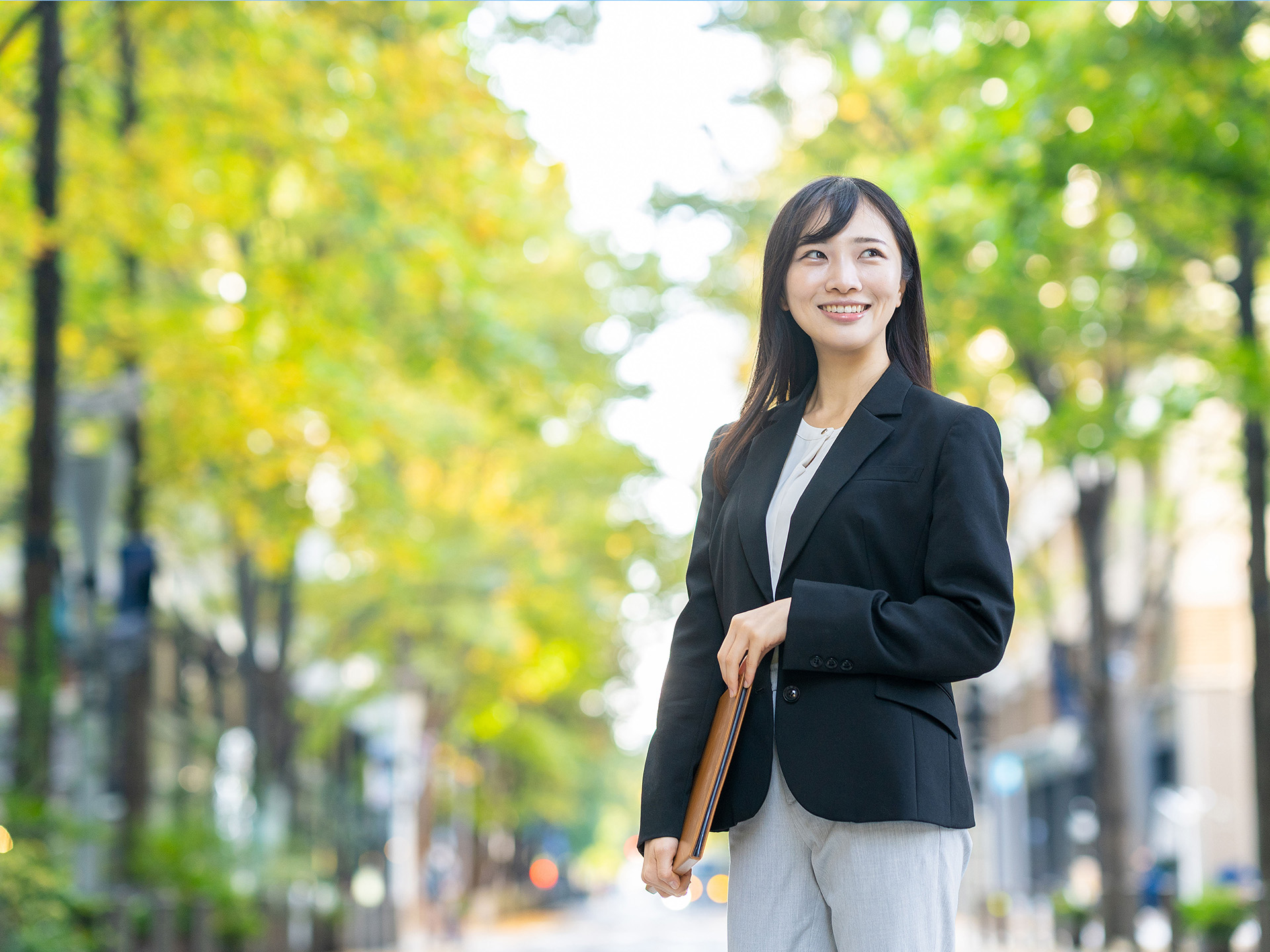 ファイルを手に持ち微笑む女性